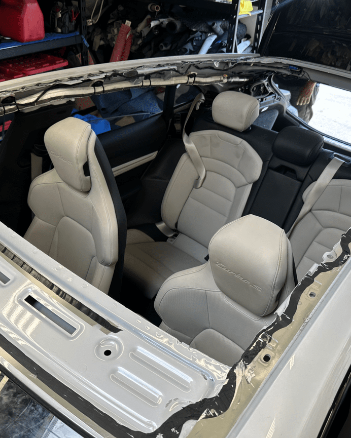Porsche Taycan interior with panoramic roof glass removed, showing frame during replacement